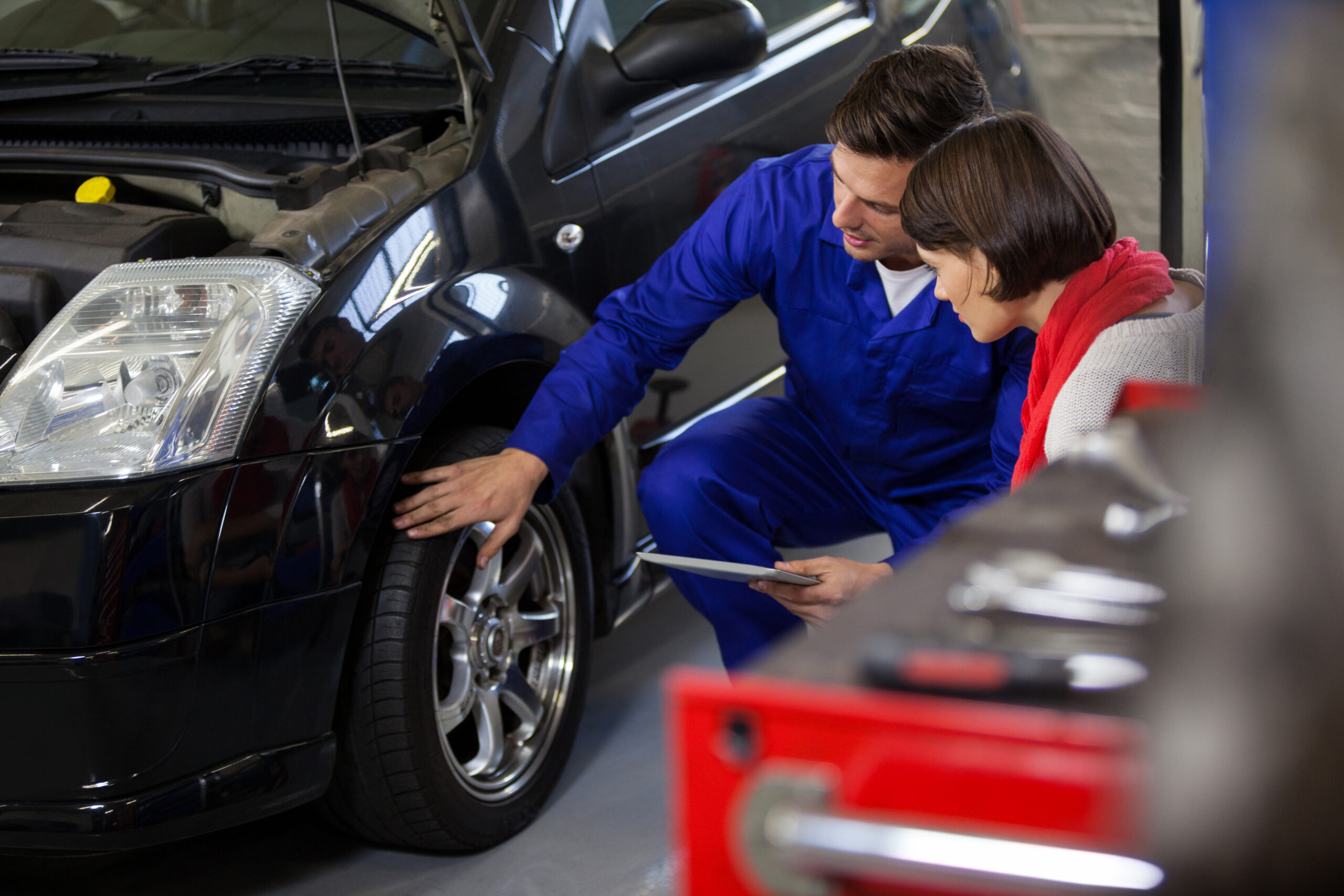 Mechanic showing customer the problem with car at the repair garage